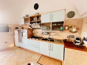 a kitchen with white cabinets and a sink at PELAGOS - Agenzia Immobilevante in Ponza