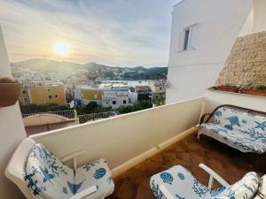 a balcony with chairs and a view of a city at PELAGOS - Agenzia Immobilevante in Ponza
