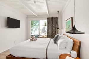 a bedroom with a large bed with a tv on the wall at The Weekend by AvantSay in Palm Springs