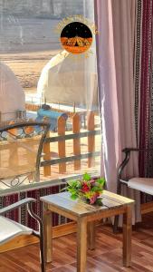 a table with flowers on it in a room at SEVEN PILLARS lUXURY CAMP in Wadi Rum