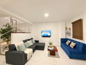 a living room with a couch and a blue couch at Casa Familiar a Pasos del Mar Playa y Felicidad in Manta