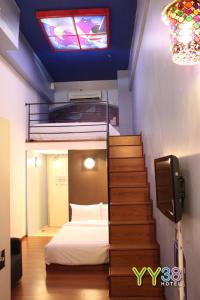 a bedroom with a bed and a staircase with a stair case at YY38 Hotel in Kuala Lumpur
