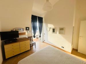 a bedroom with a bed and a dresser with a television at PELAGOS - Agenzia Immobilevante in Ponza