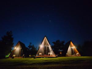 a group of three triangular tents in a field at night at Wawowow in Tomohon