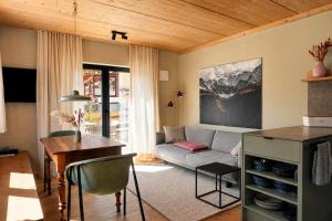 a living room with a couch and a table at Das Kofelau in Oberammergau