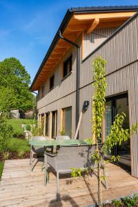 a house with a deck with a table on it at Das Kofelau in Oberammergau