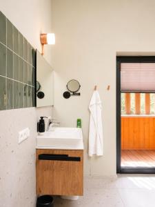 a bathroom with a white sink and a window at Das Kofelau in Oberammergau +79 photos
