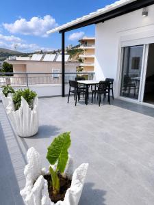 a patio with a table and chairs on a balcony at Vila Makla in Sarandë