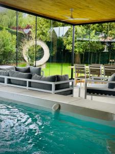 a swimming pool with a couch next to the water at Het Huis - luxury villa near Tomorrowland in Willebroek