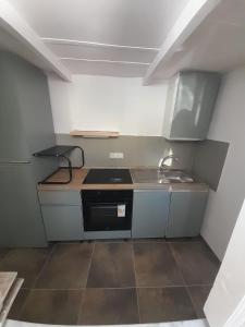 eine kleine Küche mit Spüle und Herd in der Unterkunft Lumie in Palermo