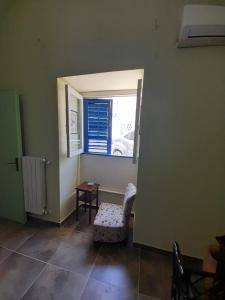 ein Zimmer mit einem Fenster, einem Stuhl und einem Tisch in der Unterkunft Lumie in Palermo + 3 Fotos