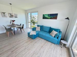 a living room with a blue couch and a table at RegioStyle-Gemuetliche-Wohnung-im-Schaalseepark in Zarrentin