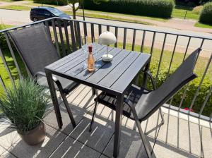 a wooden table with a bottle of beer and a chair at RegioStyle-Gemuetliche-Wohnung-im-Schaalseepark in Zarrentin