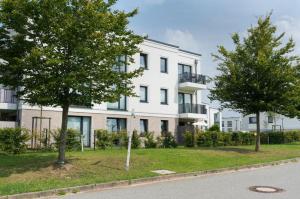 an apartment building with trees in front of it at RegioStyle-Gemuetliche-Wohnung-im-Schaalseepark in Zarrentin