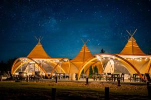 a large marquee lit up at night at Under Canvas White Mountains in Dalton