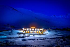 a large building in the snow at night at Demirkapı Otel in Uzungöl