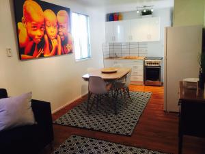 a living room with a table and a kitchen at Cottage on Cork - Muddy Cottage in Winton