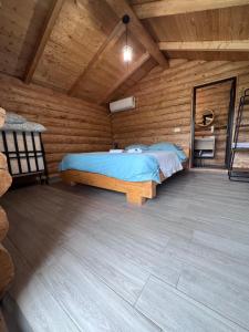 a bedroom with a bed in a wooden cabin at Cabanutele M&V INFINIT in Sălătrucel +37 photos