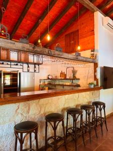 a kitchen with a bar with five stools at Etno vila Međugorje in Čapljina
