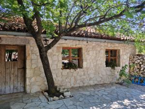 a stone house with a tree in front of it at Etno vila Međugorje in Čapljina