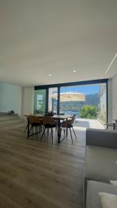 a dining room with a table and chairs and a large window at Casa Miralago - Gerês in Admeus
