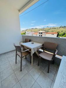 a table and chairs on a balcony with a view at Apartmani Miladinović in Sutomore