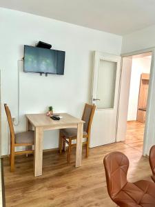 a dining room with a table and a television on the wall at Tinela in Mostar