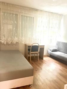 a bedroom with a bed and a table and a couch at Tinela in Mostar