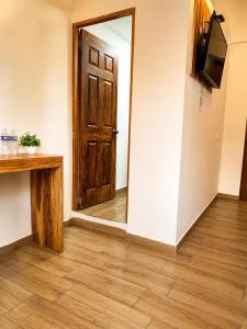 a hallway with a wooden door and a television at Palacio de las Rosas in Durango