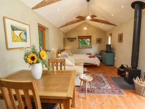 a living room with a table and a fireplace at Brambly Cabin in Crediton