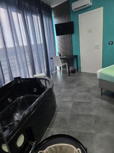 a bathroom with a black bath tub in a room at Hotel Living in Casoria