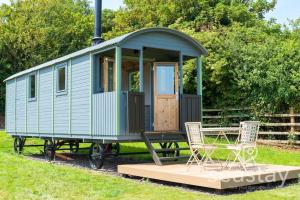 a green train car with a table and two chairs at Sea Farm Stays in Broadstairs