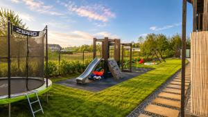 a playground with a slide in the grass at Sunmare in Sarbinowo