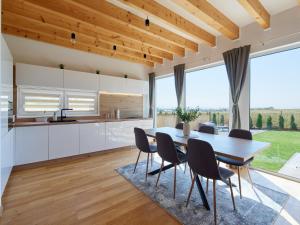 a kitchen and dining room with a table and chairs at Chaletka Tatry in Nová Lesná