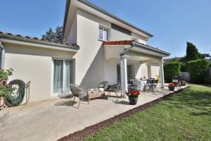 a patio of a house with chairs and tables at Villa Fontenailles in Mâcon