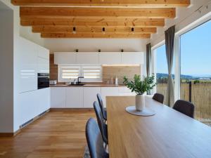 a kitchen and dining room with a wooden table and chairs at Chaletka Tatry in Nová Lesná
