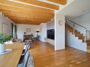 a dining room and living room with a wooden ceiling at Chaletka Tatry in Nová Lesná