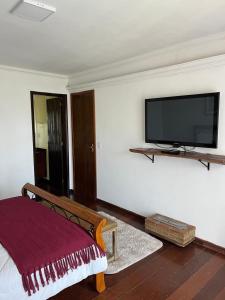 a bedroom with a flat screen tv on the wall at Alto Paraiso in Teresópolis