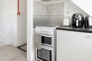a kitchen with a stove top oven next to a counter at Sky View En-Suite in Egham +13 photos