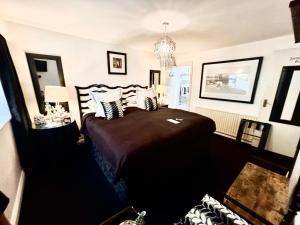 a bedroom with a large bed and a chandelier at The K Kinsale in Kinsale +23 photos