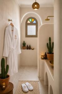 a white robe hanging in a bathroom with a cactus at Riad Sesame in Marrakesh +34 photos