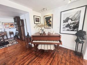 a piano in a living room with a wooden floor at The K Kinsale in Kinsale