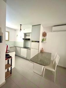 a kitchen with a table and chairs and a refrigerator at APARTBEACH NARGAM Vista Playa in La Pineda