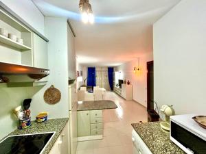 a kitchen with white cabinets and a living room at APARTBEACH NARGAM Vista Playa in La Pineda