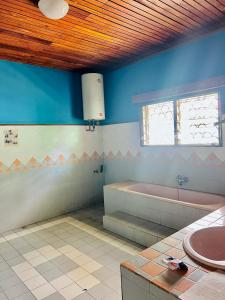 a bathroom with a bath tub and a sink at Villa Rapide in Ambanja