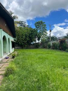 a yard with green grass next to a house at Villa Rapide in Ambanja