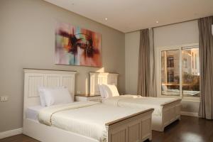 a bedroom with two beds and a painting on the wall at Munir`s residence 2 in Cairo