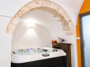 a bath tub in a bathroom with an archway at Ostuni Luxury Room in Ostuni