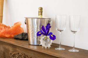 a bottle of wine in a bucket next to two wine glasses at Ostuni Luxury Room in Ostuni