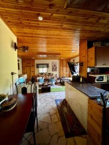 a kitchen and living room with wooden ceilings and a table at Oak Farm مزرعة الملّول in Ajloun